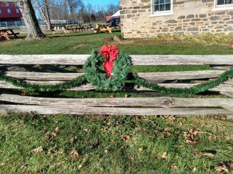 Wreath and garland hanging on a wooden fence